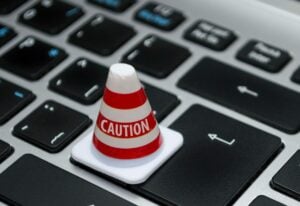 A computer keyboard with a warning cone on it